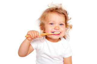 Cute baby toddler brushing teeth. Isolated on white background.